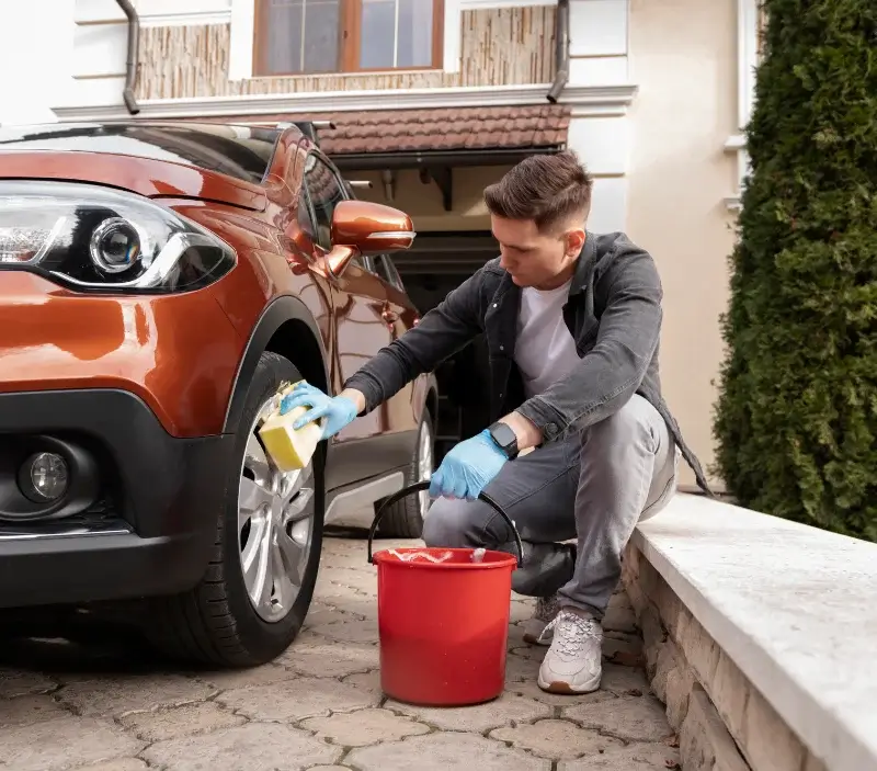 Lavage auto à domicile Condé-sur-Sarthe : professionnel intervenant sur un véhicule